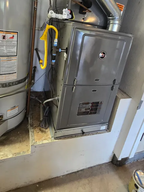 A gas furnace and its vent pipe beside a water heater